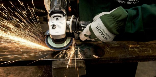 Close-up of a skilled worker using a grinder with sparks flying in a metal workshop.