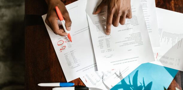 Overhead view of hands highlighting financial documents on a desk.